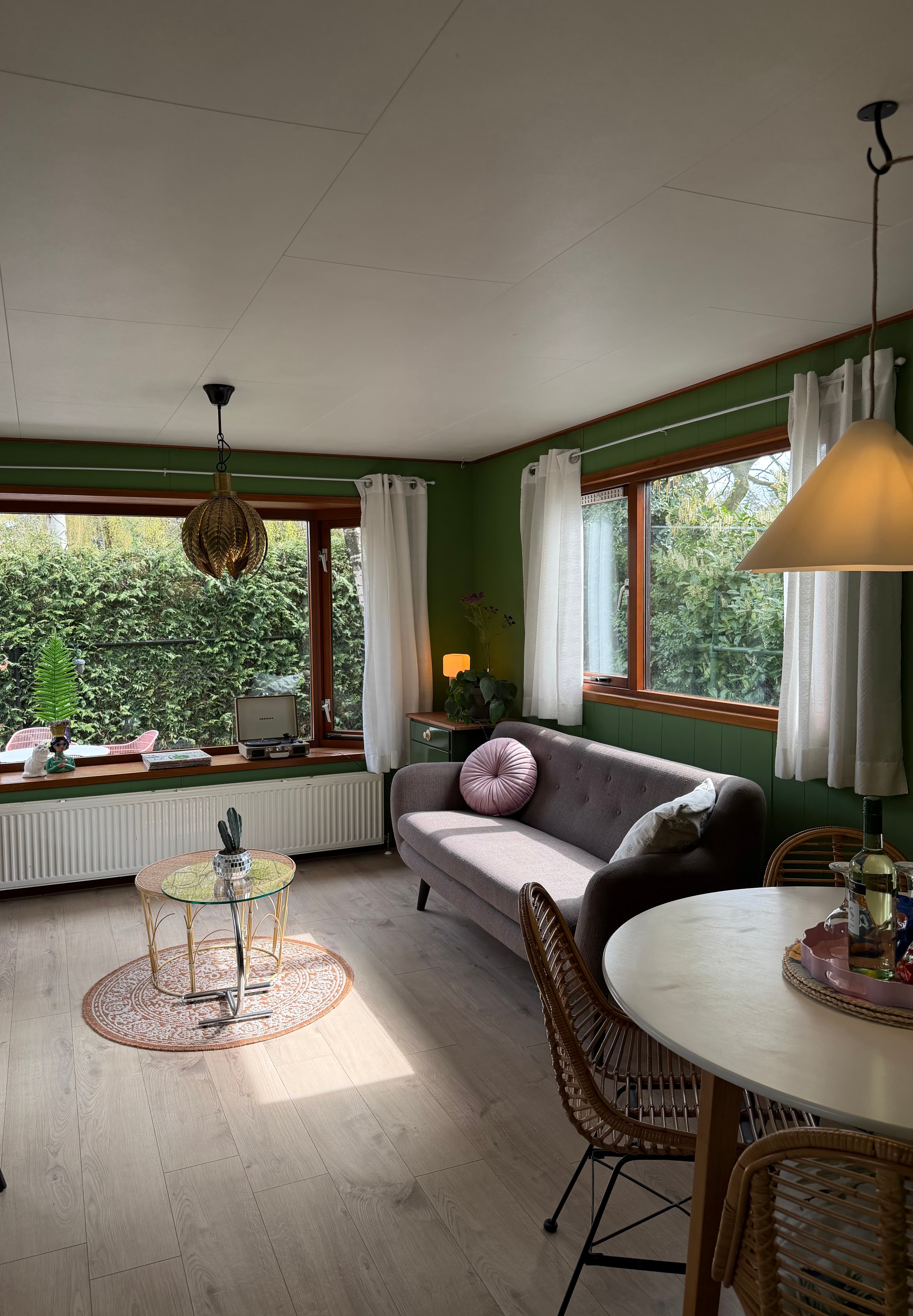 Zithoek en eetkamer van Bosbreak met groene wanden en natuurlijk licht